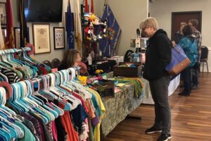 Guests at the Gold Star Venue at the VFW in Rochester, MN are viewing the sales of clothing at indoor market and craft sale.